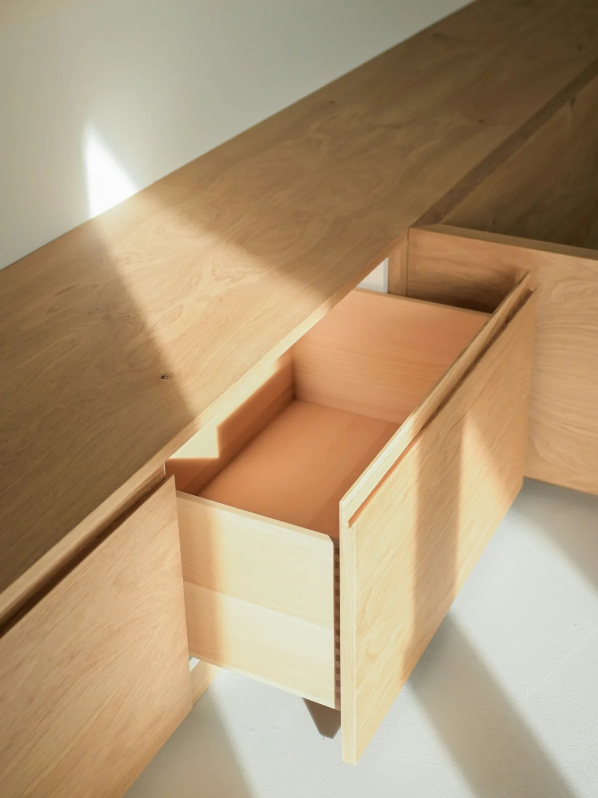 Wooden drawer pulled open in raking daylight — Werzit portfolio thumbnail
